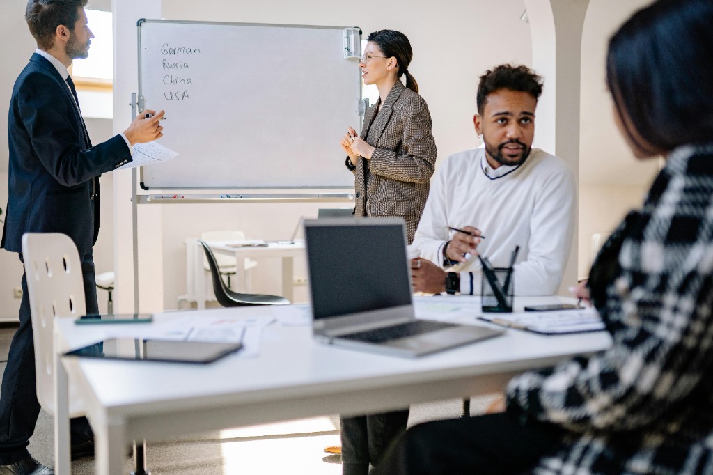 Consulting team collaborating at a whiteboard in a bright modern conference room